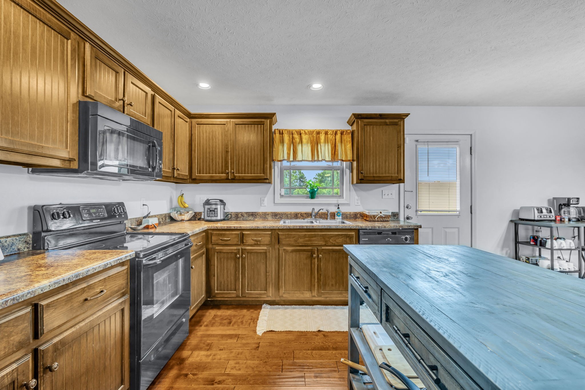 2164 Akersville Road Lafayette, TN 37083 - Photo 21 of 32 a kitchen with stainless steel appliances granite countertop a sink stove and cabinets
