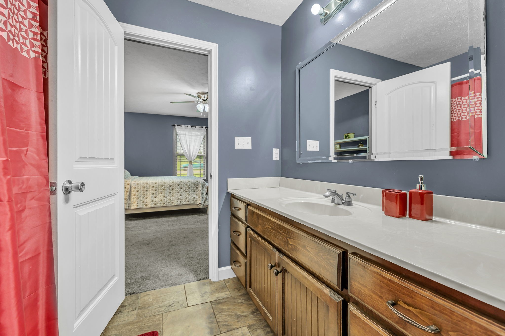 2164 Akersville Road Lafayette, TN 37083 - Photo 32 of 32 a en suite bathroom with a granite countertop sink and a mirror