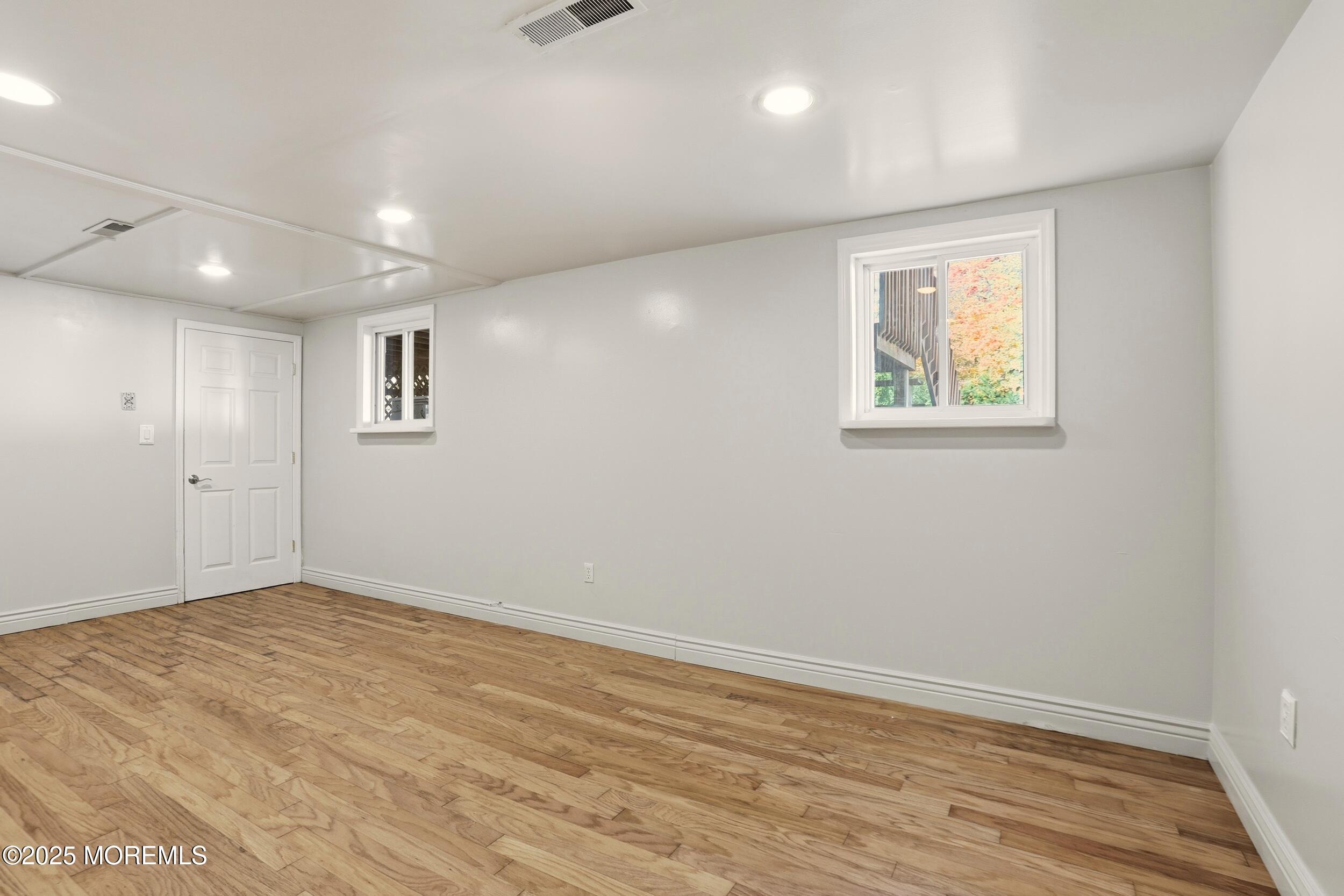 19 Kensington Drive Howell, NJ 07731 - Photo 11 of 31 an empty room with wooden floor and windows