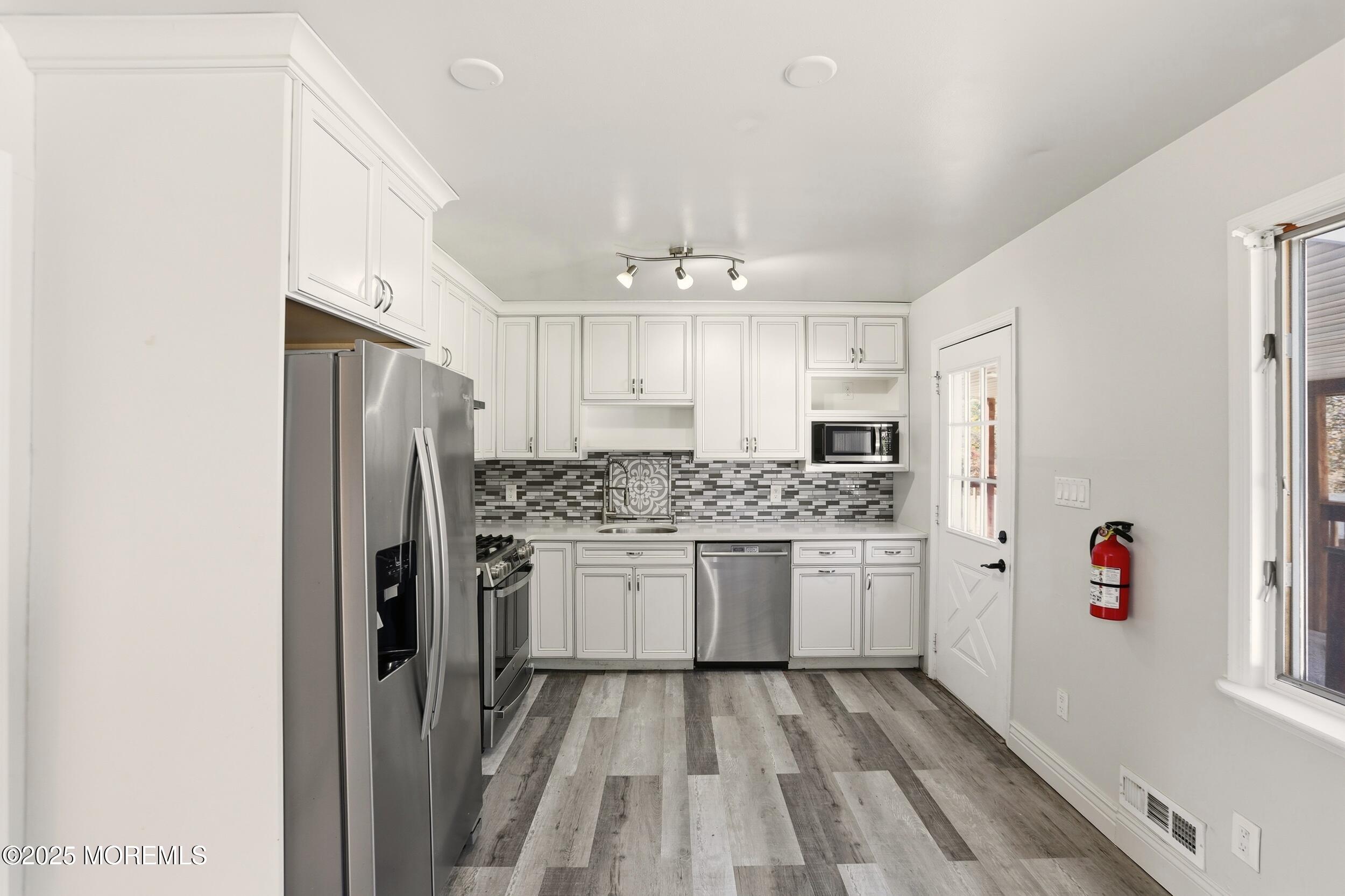 19 Kensington Drive Howell, NJ 07731 - Photo 22 of 31 a kitchen with stainless steel appliances a refrigerator and a stove top oven