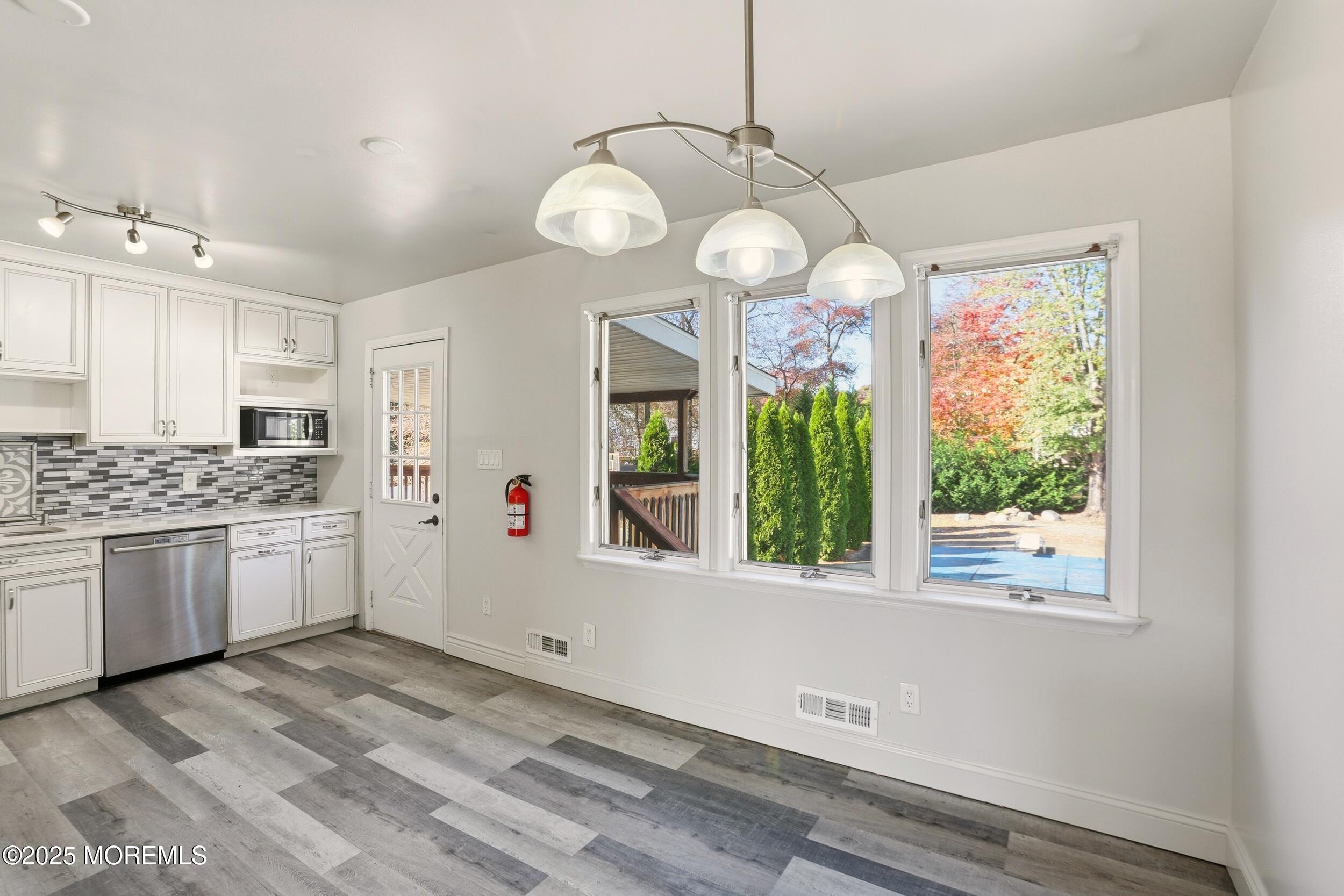 19 Kensington Drive Howell, NJ 07731 - Photo 24 of 31 a open kitchen with a refrigerator a stove top oven a large window with wooden floor and cabinets