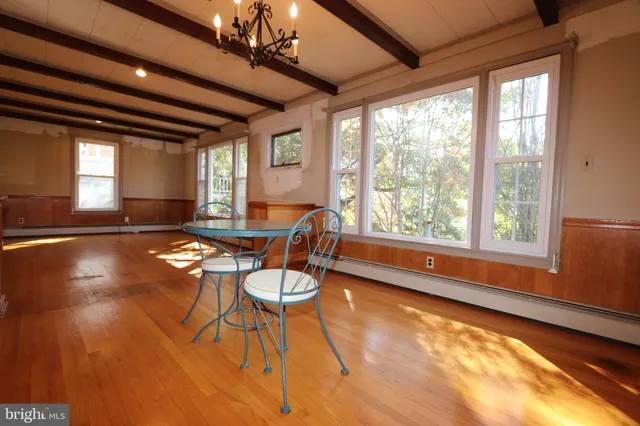 a dining room with furniture and a large window
