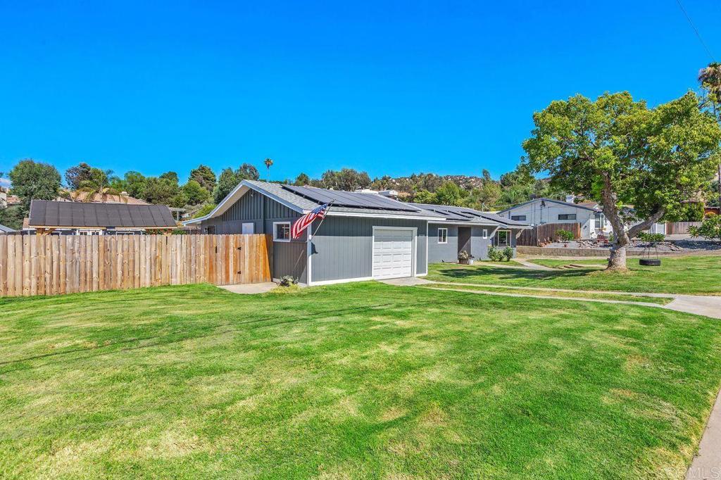 a view of a house with a big yard plants and large trees