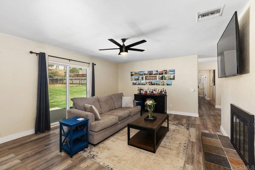 8229 Medill Avenue El Cajon, CA 92021 - Photo 14 of 34 a living room with furniture a fireplace and a flat screen tv