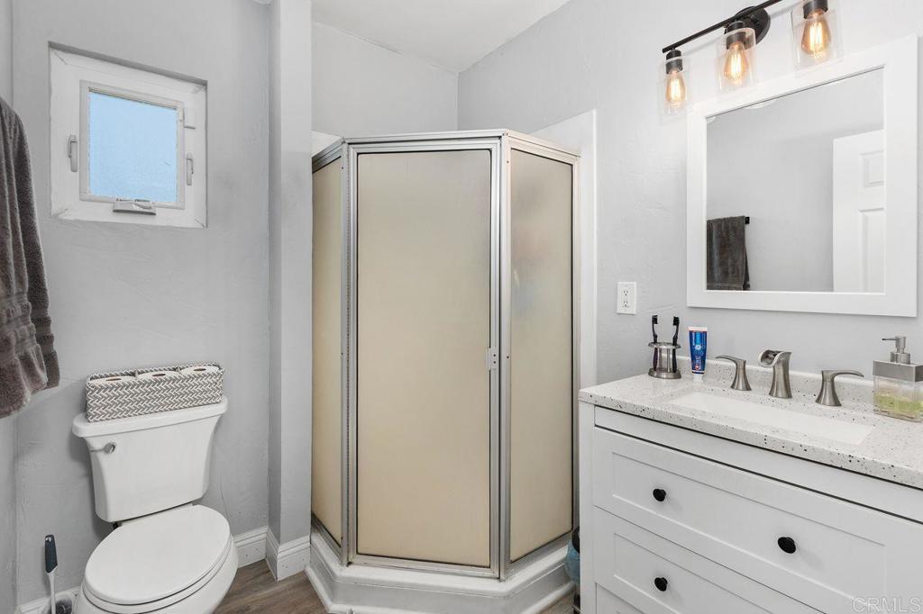 8229 Medill Avenue El Cajon, CA 92021 - Photo 19 of 34 a bathroom with a toilet a sink a vanity and mirror