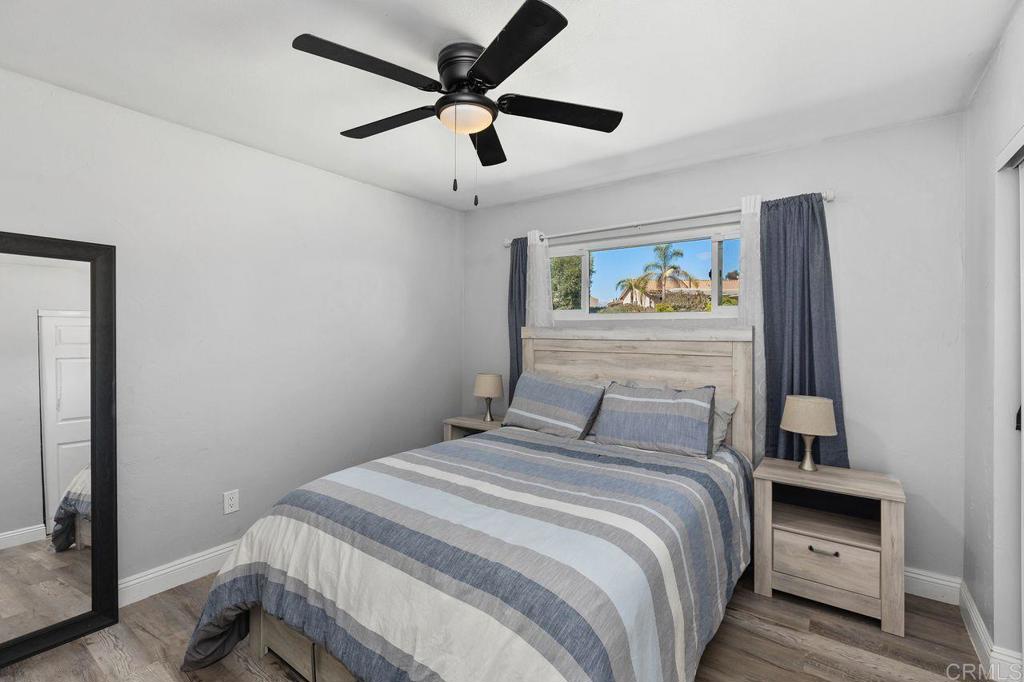 8229 Medill Avenue El Cajon, CA 92021 - Photo 21 of 34 a bedroom with a large bed and a chandelier