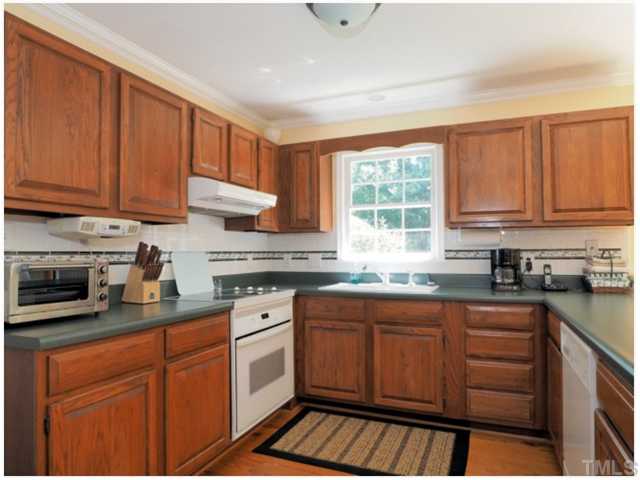 6208 Dresden Lane Raleigh, NC 27612 - Photo 4 of 25 a kitchen with granite countertop wooden cabinets stainless steel appliances a sink and a window