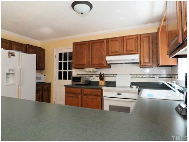 6208 Dresden Lane Raleigh, NC 27612 - Photo 5 of 25 a kitchen with granite countertop a refrigerator stove top oven a sink and dishwasher