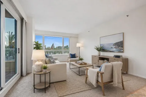 a living room with furniture fireplace and a large window