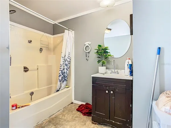 a bathroom with a sink vanity mirror and a bathtub