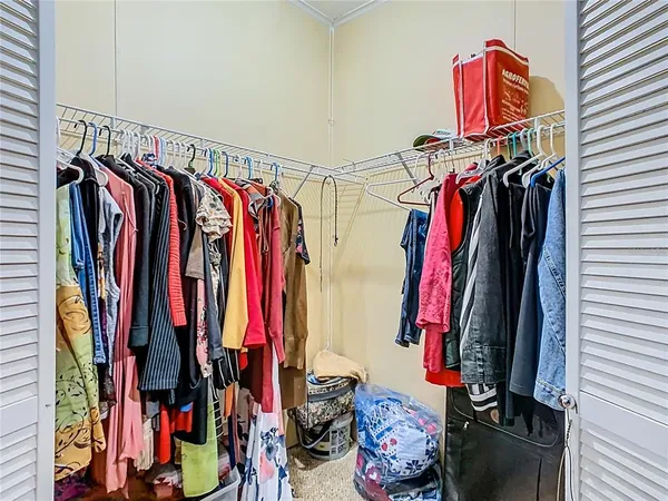 a view of walk in closet with clothes