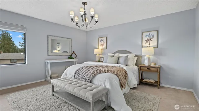a bedroom with a bed and a chandelier