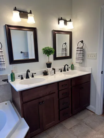 a bathroom with a bathtub and a double vanity sink