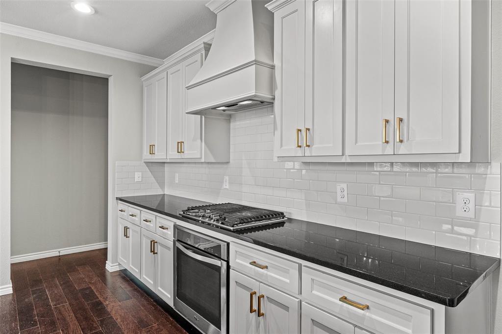 437 Prairie Run Aledo, TX 76008 - Photo 8 of 33 Gourmet kitchen with white shaker cabinetry, gold-finish hardware, black countertops, a subway tile backsplash, and a built-in gas range with an oven