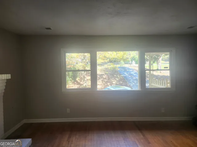 a view of a room with wooden floor and windows