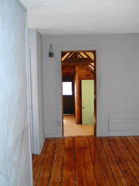 128 Pleasant Street, Unit 2 Marblehead, MA 01945 - Photo 4 of 13 a view of an empty room with wooden floor and a window