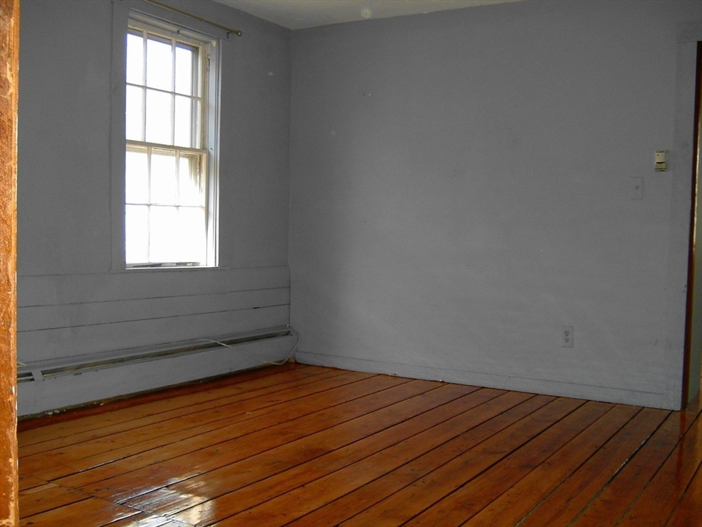 128 Pleasant Street, Unit 2 Marblehead, MA 01945 - Photo 6 of 13 a view of empty room with wooden floor and fan
