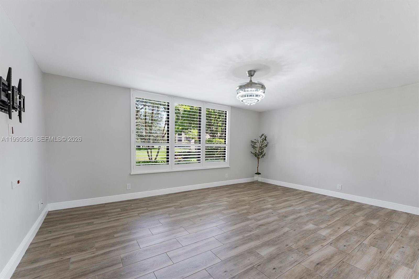 7225 Promenade Drive, Unit 102 Boca Raton, FL 33433 - Photo 12 of 21 a view of an empty room with wooden floor and a window