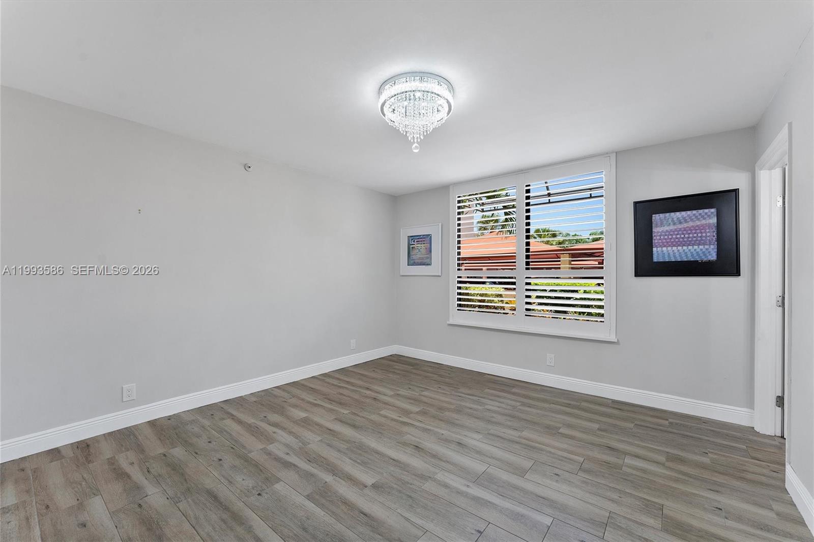 7225 Promenade Drive, Unit 102 Boca Raton, FL 33433 - Photo 13 of 21 a view of an empty room with wooden floor and a window