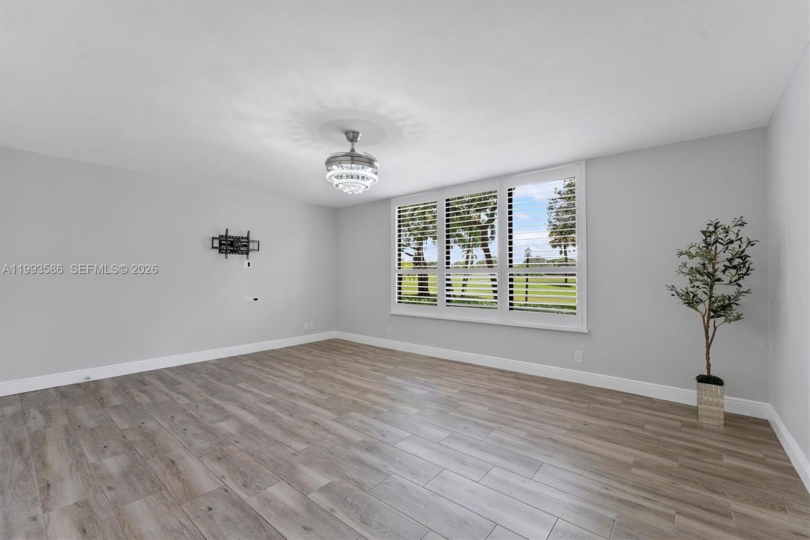 7225 Promenade Drive, Unit 102 Boca Raton, FL 33433 - Photo 14 of 21 a view of an empty room with a window and wooden floor