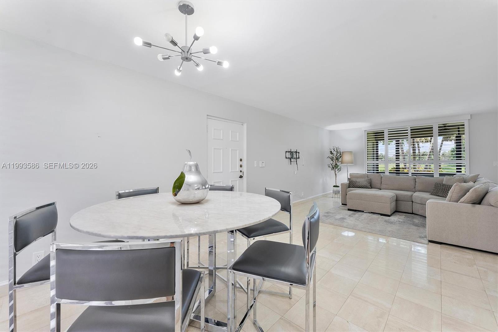 7225 Promenade Drive, Unit 102 Boca Raton, FL 33433 - Photo 5 of 21 a view of a dining room with furniture and a chandelier