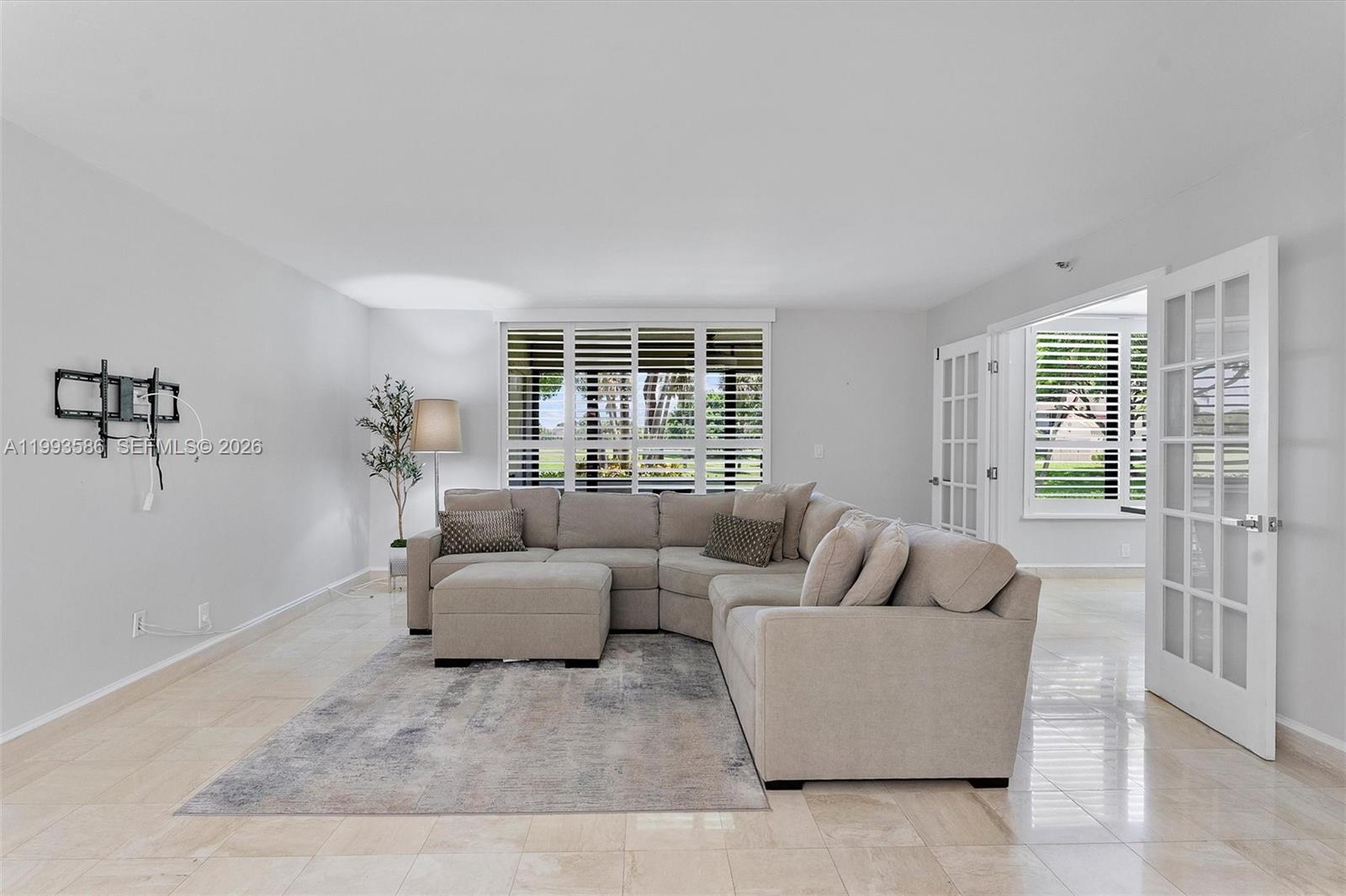 7225 Promenade Drive, Unit 102 Boca Raton, FL 33433 - Photo 7 of 21 a living room with furniture and a large window