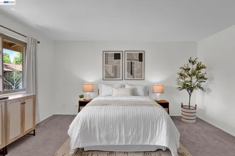 a bedroom with a bed lamp and a potted plant