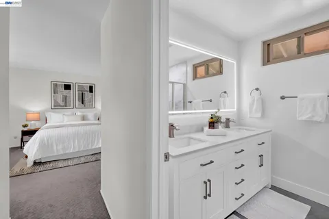 a en suite bathroom with a granite countertop sink and a mirror
