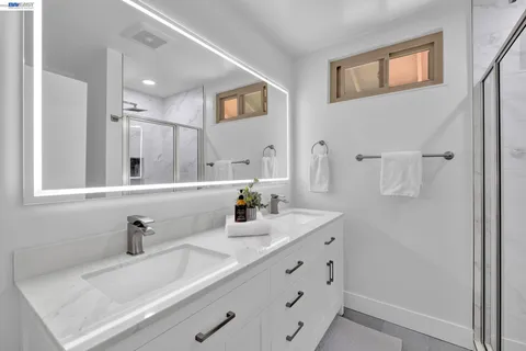 a bathroom with double vanity sink and a mirror