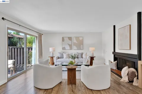 a living room with furniture a large window and wooden floor