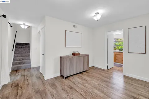 a view of a hallway with wooden floor and stairs