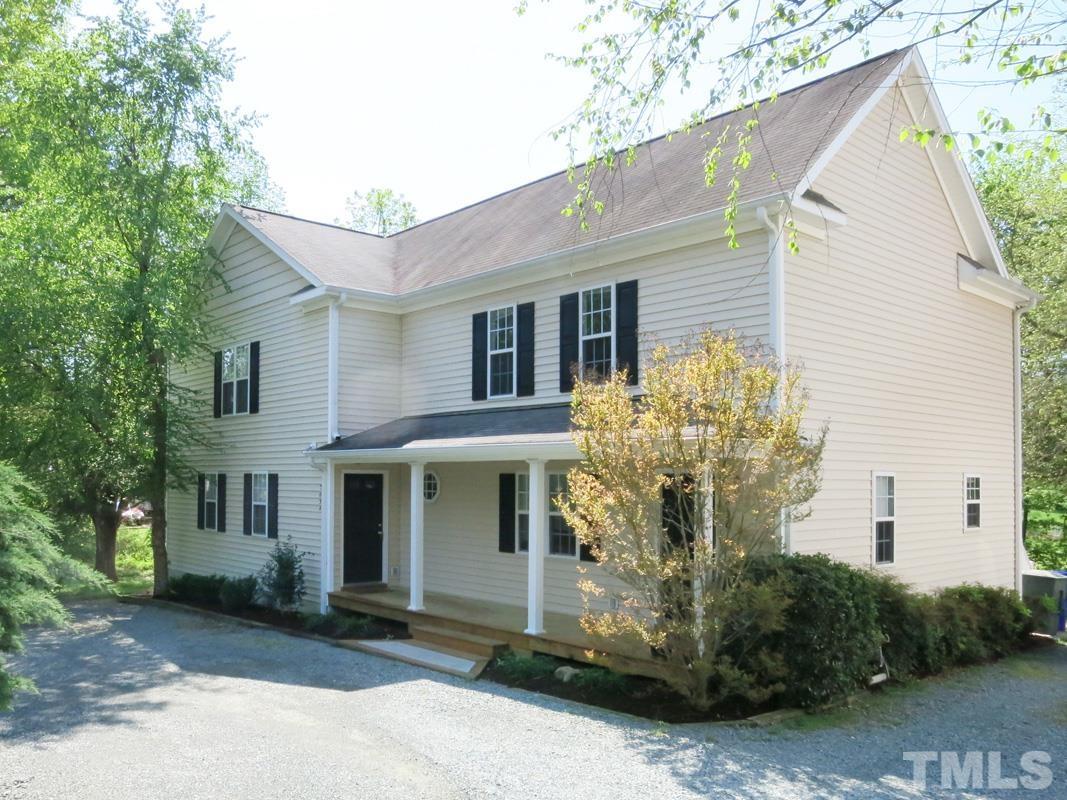 303 West Poplar Avenue, Unit B Carrboro, NC 27510 - Photo 16 of 16 a view of a white house with a large windows and potted plants