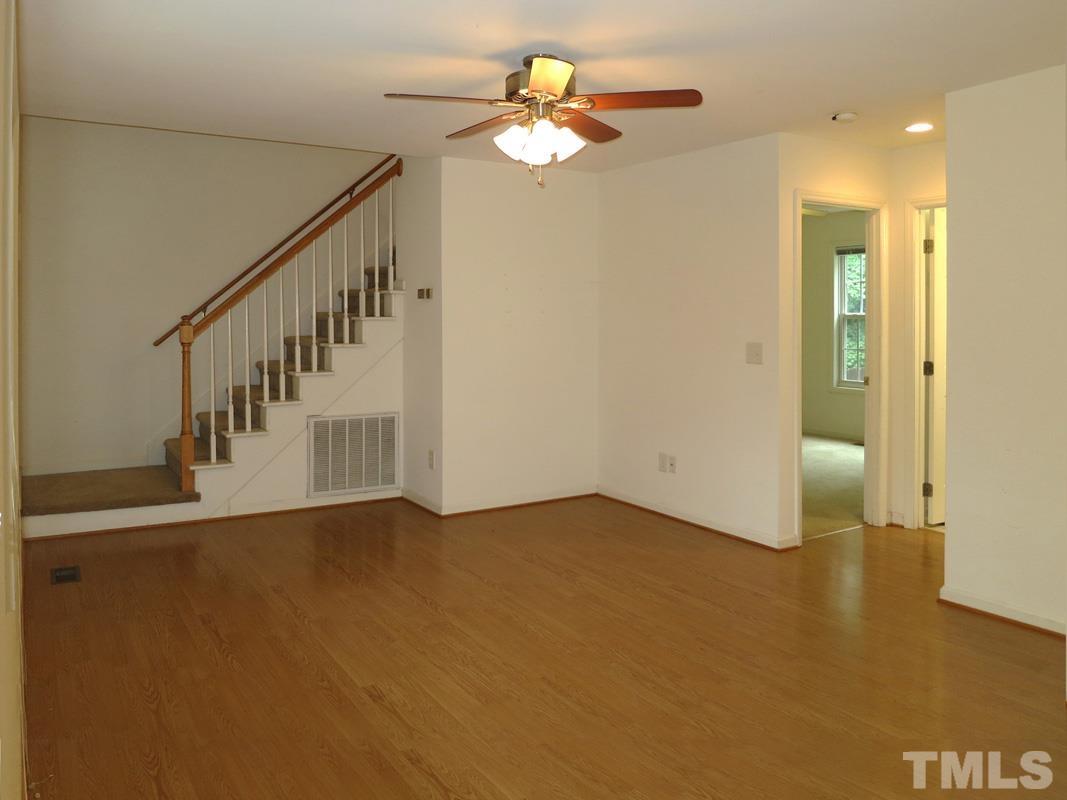 303 West Poplar Avenue, Unit B Carrboro, NC 27510 - Photo 2 of 16 a view of an empty room with chandelier fan and wooden floor