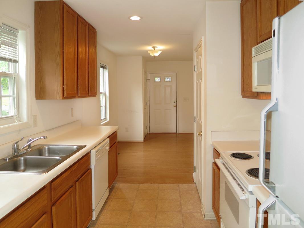 303 West Poplar Avenue, Unit B Carrboro, NC 27510 - Photo 7 of 16 a kitchen with a sink a stove and cabinets