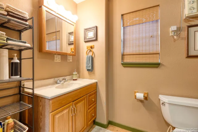 a bathroom with a sink mirror vanity and toilet