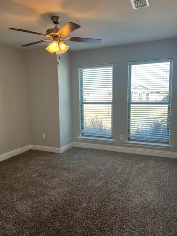 an empty room with window and chandelier fan