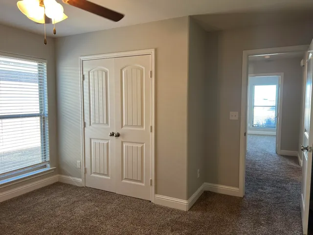 an empty room with windows and closet