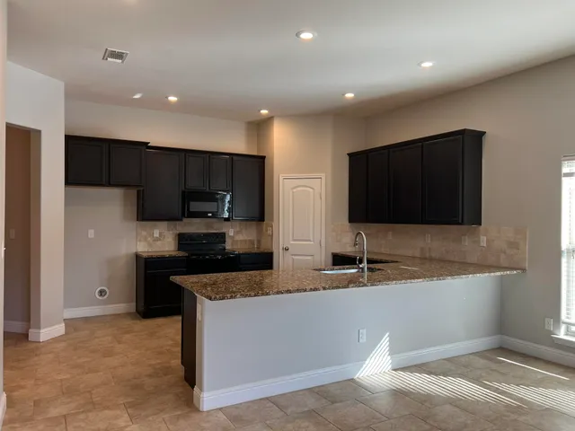 a kitchen with stainless steel appliances a microwave a sink and a refrigerator