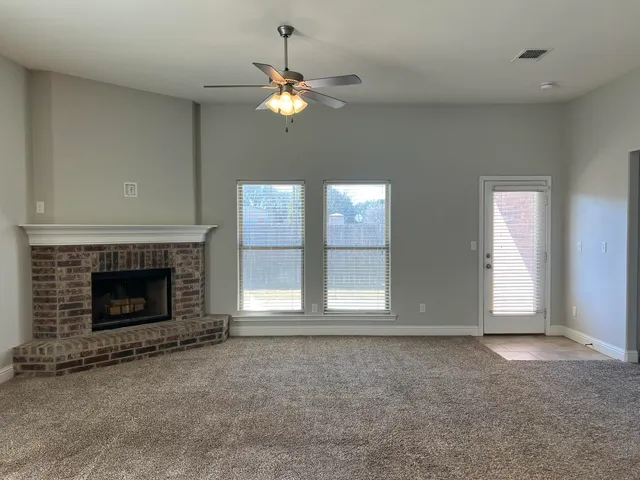 wooden floor fireplace and windows in an empty room