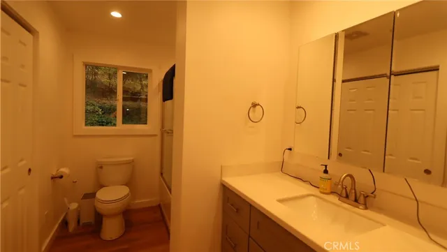 a bathroom with a granite countertop sink toilet and shower