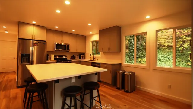 a kitchen with stainless steel appliances kitchen island granite countertop a refrigerator a stove a sink dishwasher with a dining table and chairs