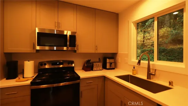 a kitchen with a sink a stove and a microwave