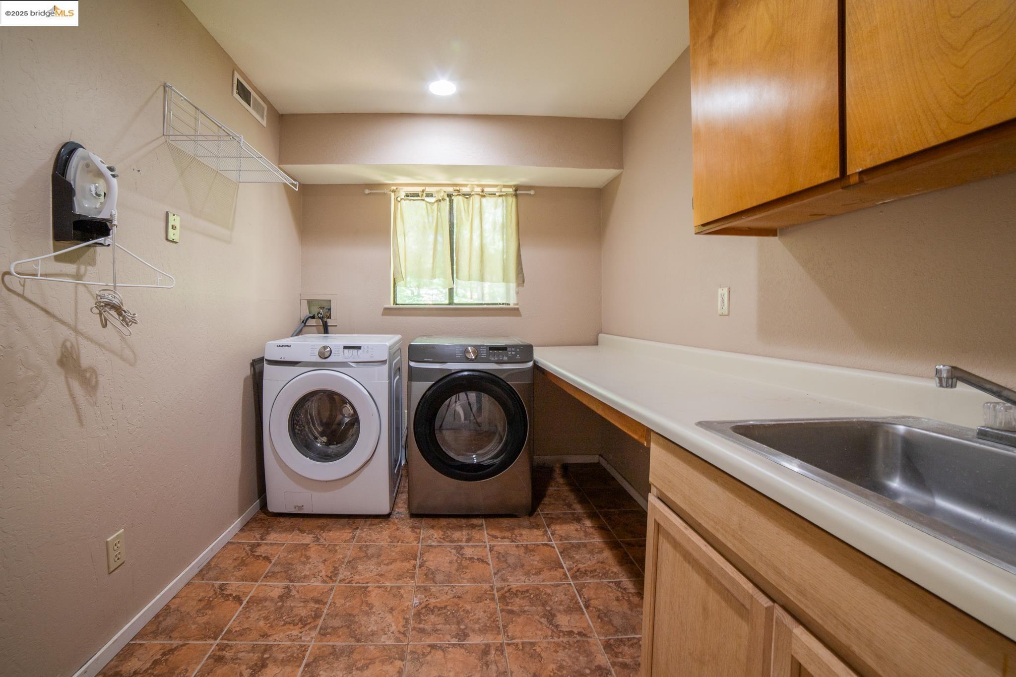 24327 Kewin Mill Road Sonora, CA 95370 - Photo 25 of 42 Laundry room with washing machine and clothes dryer and cabinet space