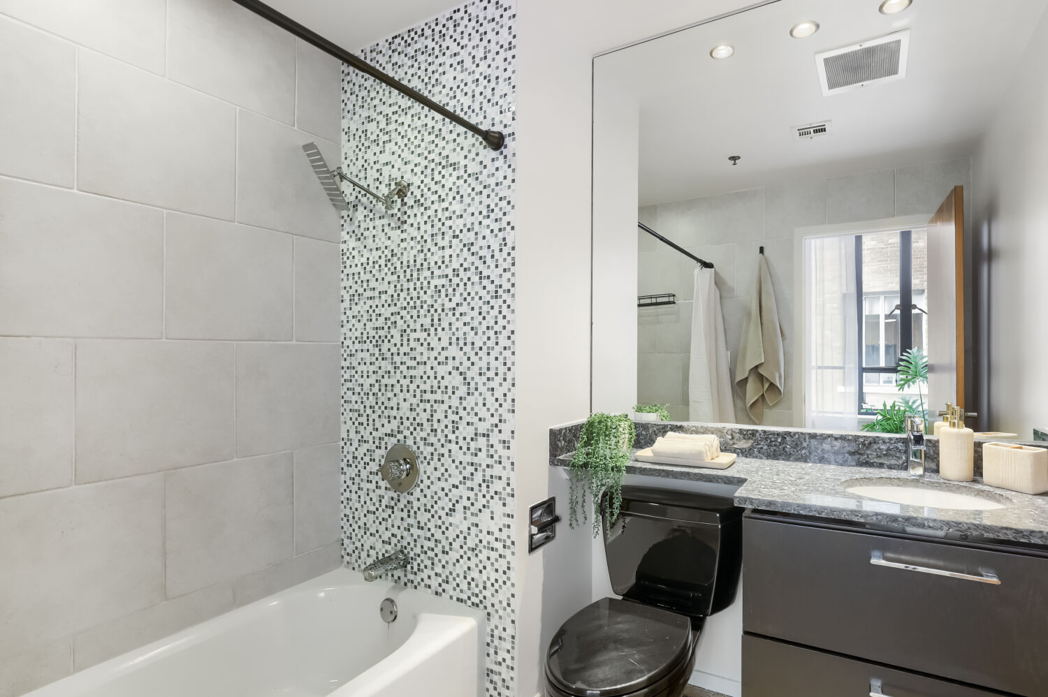710 Colorado Street, Unit 4A Austin, TX 78701 - Photo 18 of 40 The full bath features a shower/tub combo with tasteful tile backsplash that pairs well with the terrazzo floors.