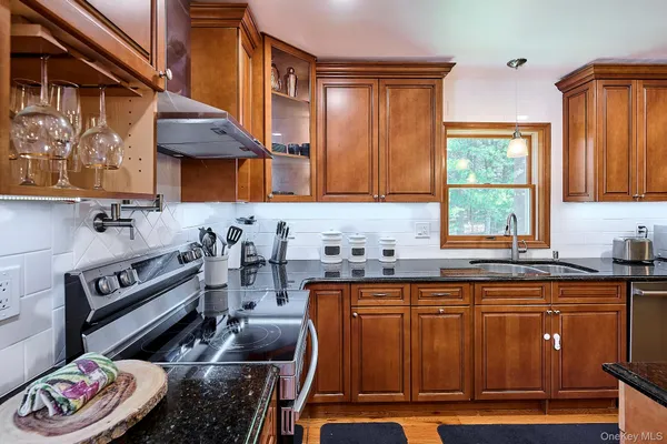 a kitchen with granite countertop a stove and a sink