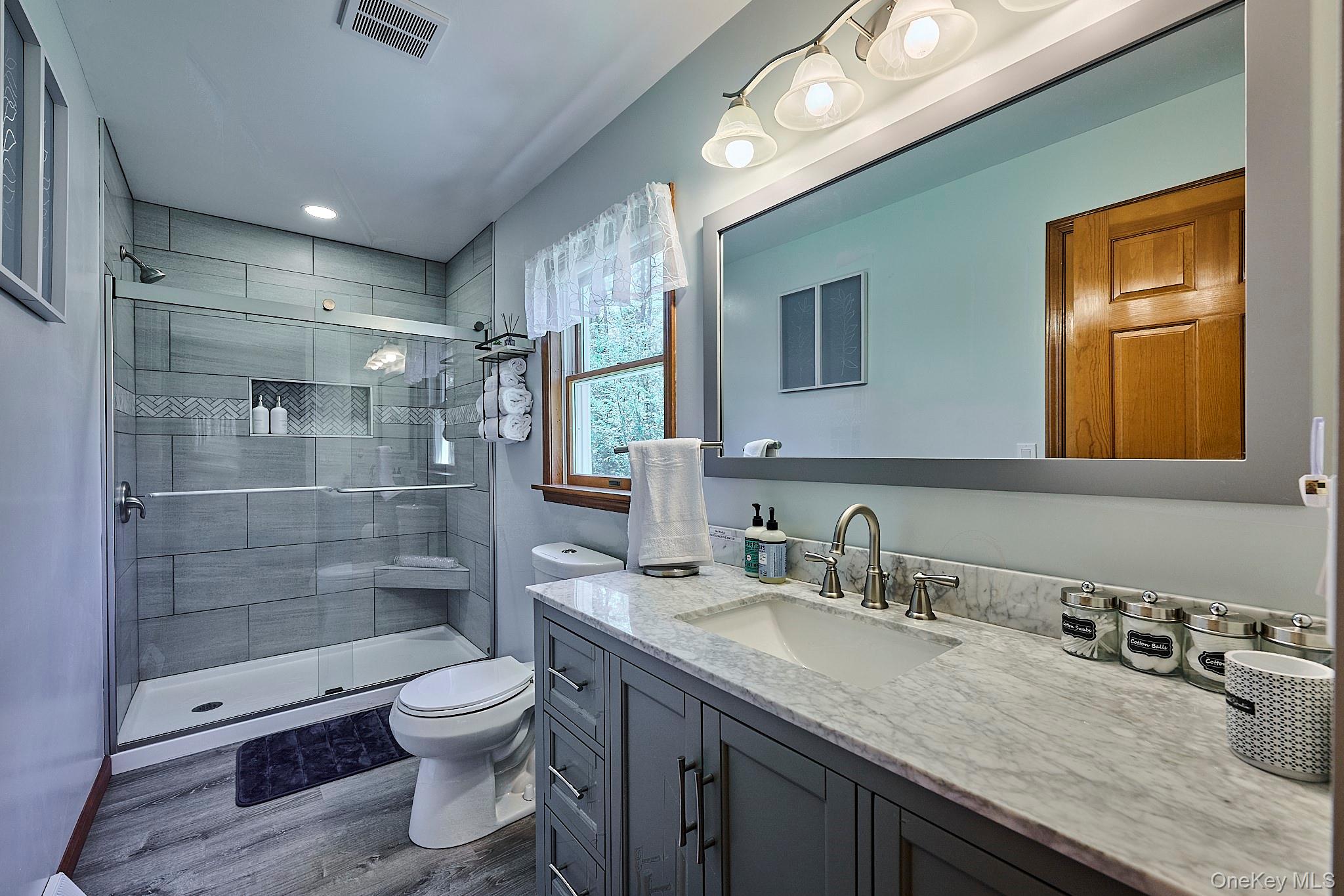 39 Pitio Road Glen Spey, NY 12737 - Photo 17 of 45 a bathroom with a granite countertop sink a toilet a mirror and shower