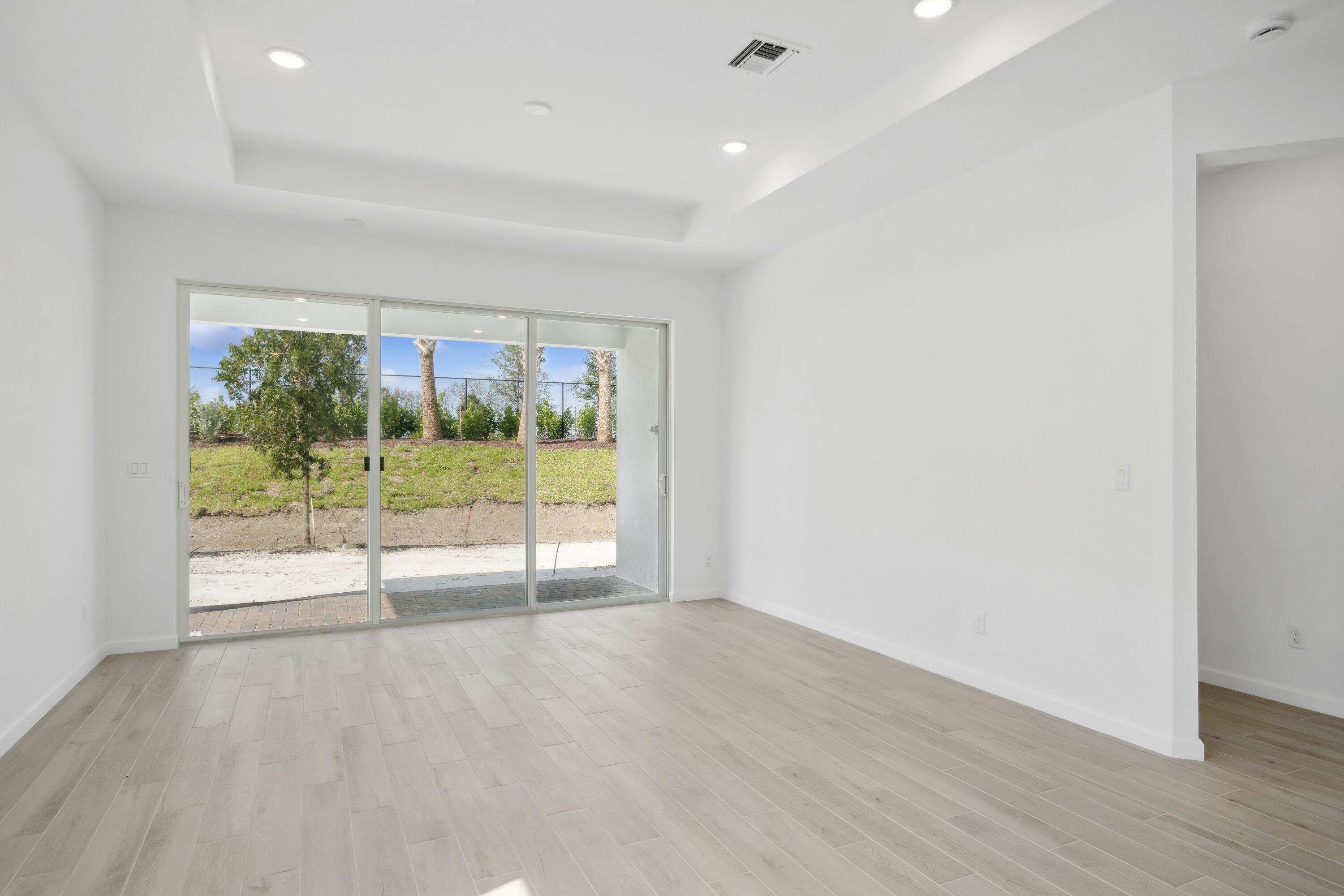 10099 Dreamweaver Road, Unit 51 Port St. Lucie, FL 34987 - Photo 11 of 36 wooden floor in an empty room with a window