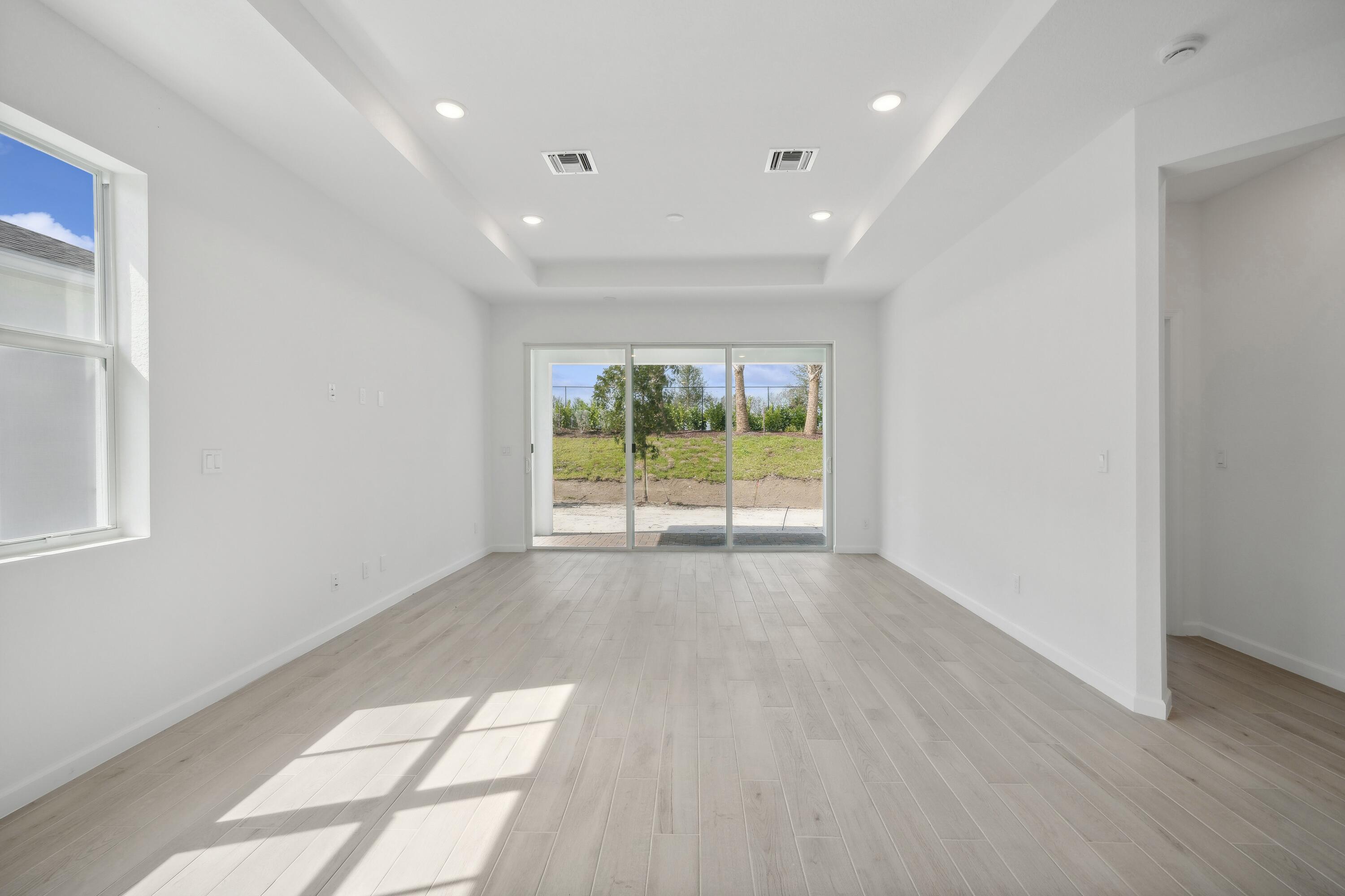 10099 Dreamweaver Road, Unit 51 Port St. Lucie, FL 34987 - Photo 13 of 36 wooden floor in an empty room with a window