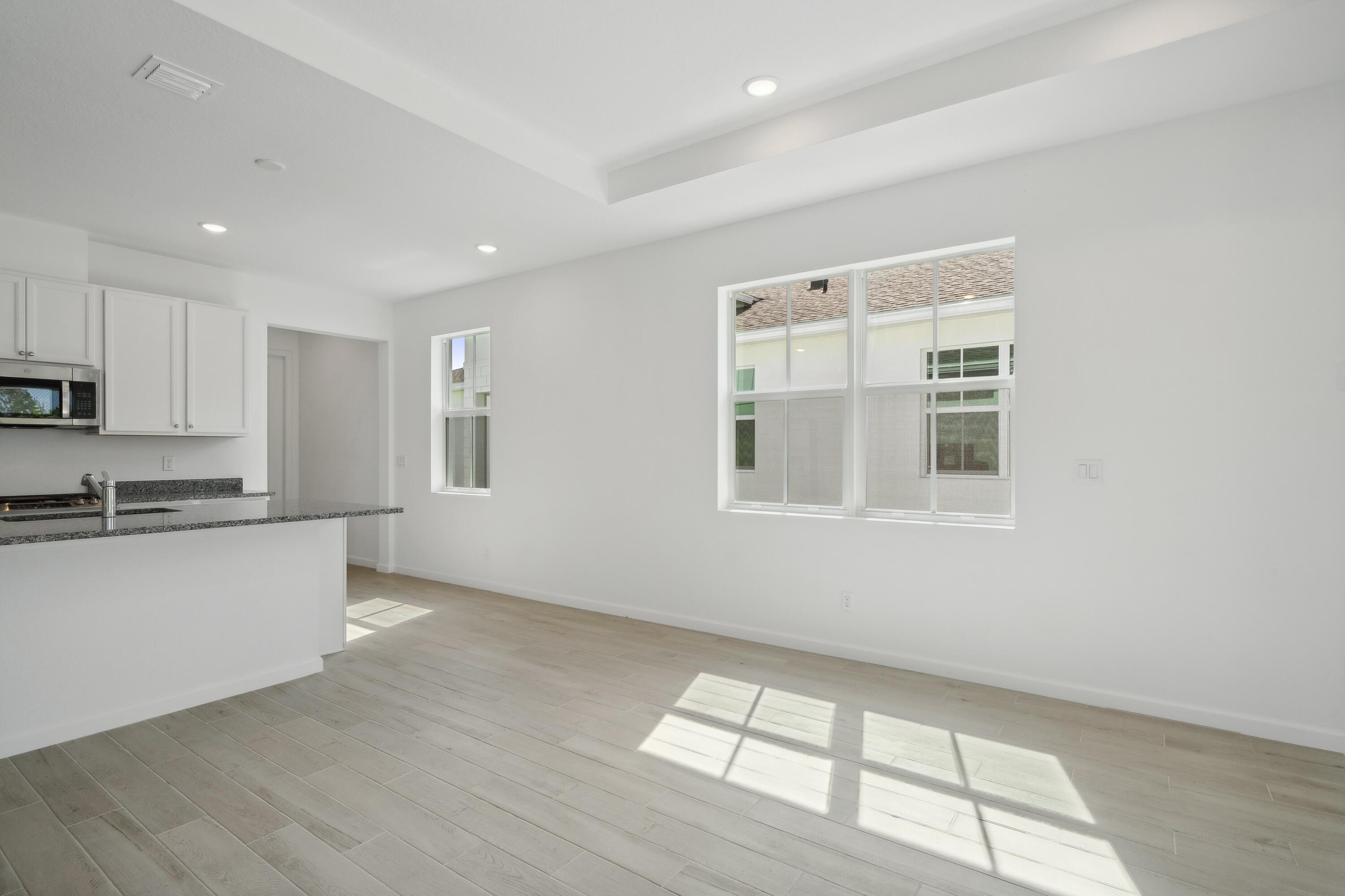 10099 Dreamweaver Road, Unit 51 Port St. Lucie, FL 34987 - Photo 14 of 36 a kitchen with granite countertop white cabinets and window