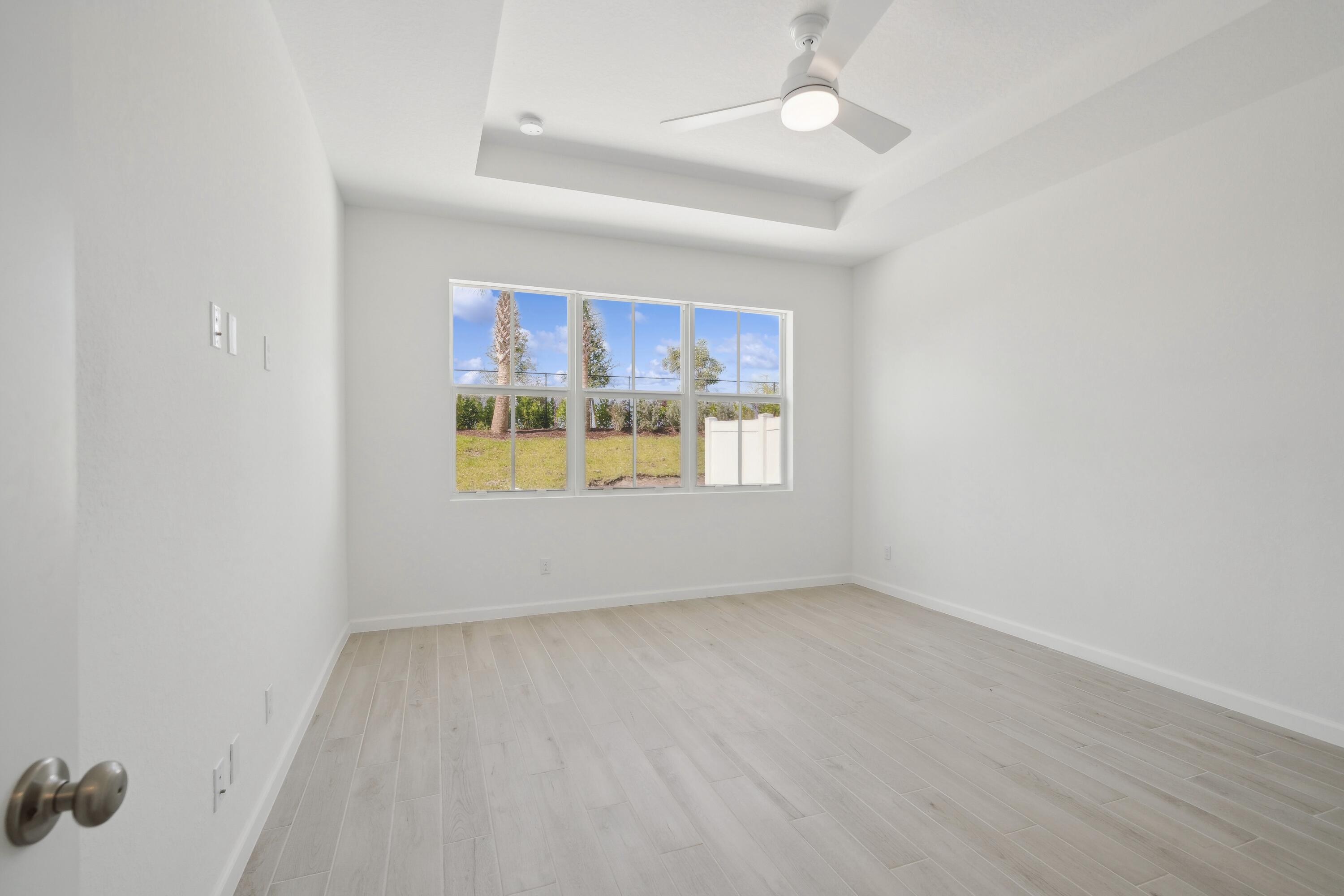10099 Dreamweaver Road, Unit 51 Port St. Lucie, FL 34987 - Photo 20 of 36 an empty room with windows and ceiling fan